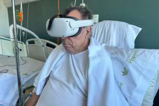 Pacient oncològic hospitalitzat provant les ulleres de Realitat Virtual