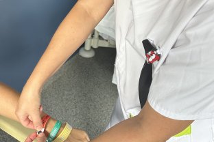 Una profesional colocando las dos nuevas pulseras a una paciente